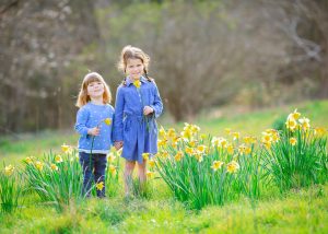 sisters playing in the daffodils at Wandlebury Country Park during a family photoshoot