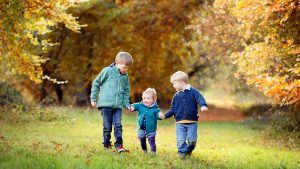 siblings holding hands on an Autumn photo shoot in Newmarket