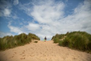 small boy on the sand dunes at Burnham Overy Staithe in Norfolk during a family photo shoot