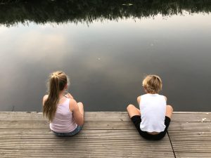 children sitting on a jetty on the River Cam in Cambridge