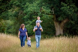 young family enjoying a walk through a field in Cambridgeshire