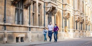 family walking along Trinity Street, Cambridge during a photoshoot