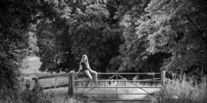 girl sitting on a gate during a summer family photoshoot in Newmarket