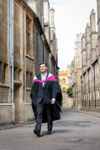 Cambridge student in graduation robes photographed on Trinity Lane